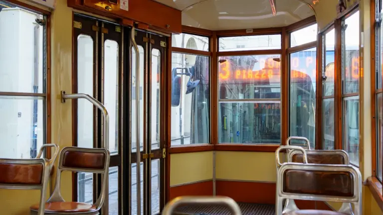Tukšs vintage tramvaja salons ar koka sēdekļiem un vēsturisku noskaņu.