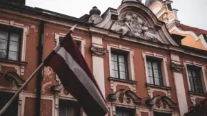 Latvijas valsts karogs plīvo pie vēsturiskas ēkas Rīgas centrā vēlēšanu laikā.