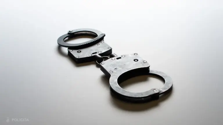 Metāla rokasdzelži novietoti uz gaiša fona, apakšējā stūrī redzams uzraksts Policija.